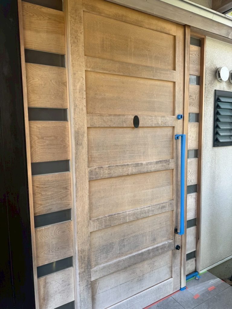 日焼けや汚れがある無垢素材の玄関扉